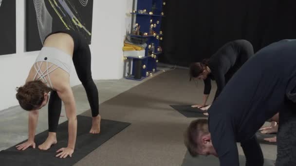 Master yogi lyfter försiktigt upp benet när du utför övningen — Stockvideo