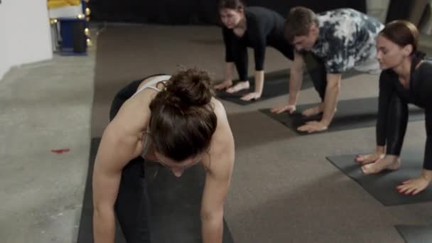 Νεαρή γυναίκα προπονητής πρακτική γιόγκα με την ομάδα κάνει Σφίγγα άσκηση — Αρχείο Βίντεο