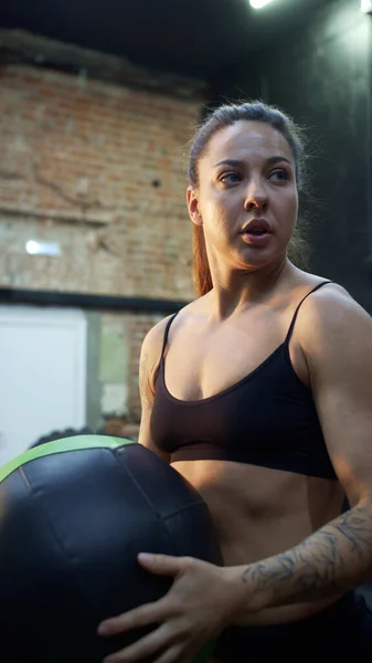 Una mujer atlética fuerte está entrenando con una pelota — Foto de Stock