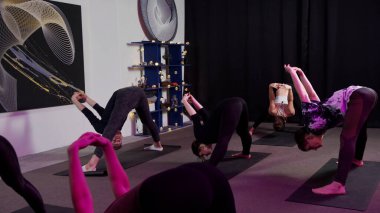 Koç yoga dersinde kolların ve bacakların doğru pozisyonu gösteriyor.