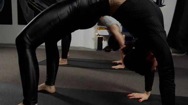 瑜伽课上，站在桥上伸展身体的女人摆出姿势 — 图库照片