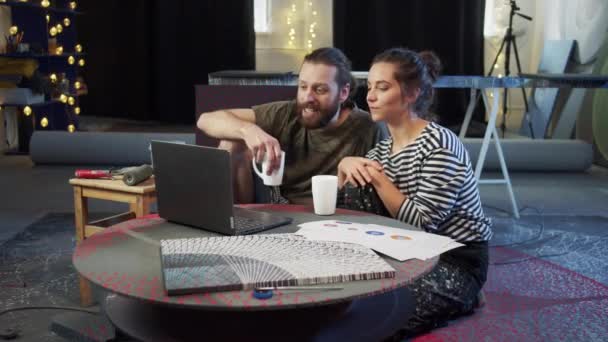 Twee schilders kijken naar iets op de computer. — Stockvideo