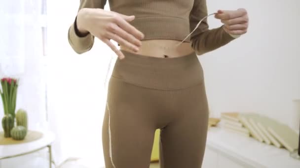 Спортивна жінка робить вимірювання її талії — стокове відео
