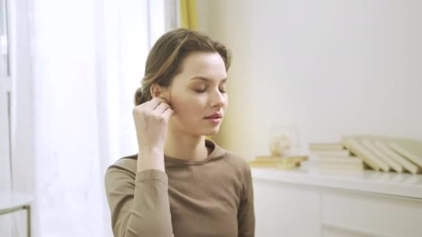 Uma mulher esportiva está ouvindo música e meditando — Vídeo de Stock