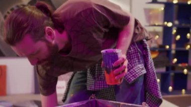 Yakışıklı bir ressam bir palette boya karıştırıyor.