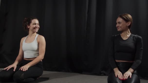 Les filles donnent high-five à l'autre tout en étant assis sur les tapis après une séance d'entraînement — Video