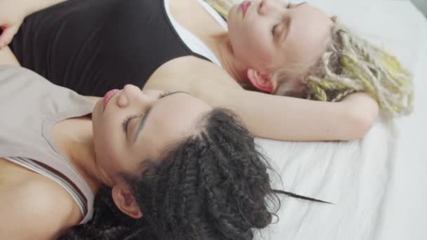 Девушка переворачивается во сне и обнимает свою подругу. — стоковое видео