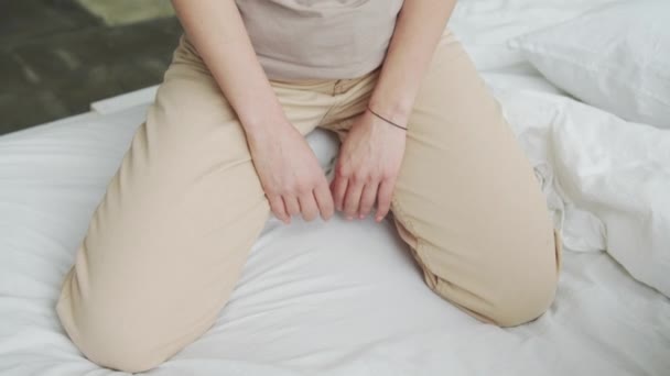 Пара сидящих в постели, колено за коленом с руками на подушке — стоковое видео