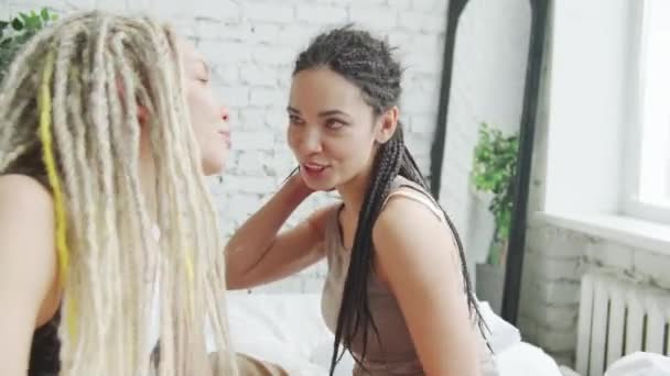 Twee meisjes zitten op het bed en lachen close-up — Stockvideo