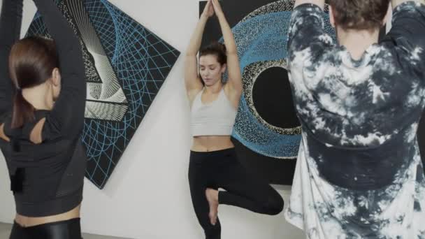 Yoga lärare som hjälper ung fitness flicka och pojke do konasana pose — Stockvideo