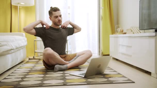 Un jeune homme attrayant regarde des vidéos et fait des exercices sains — Video