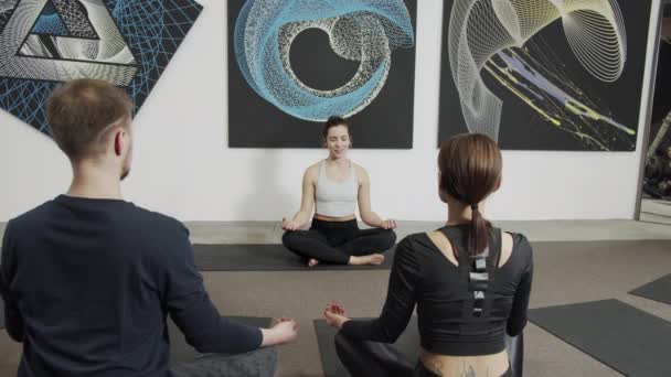 Nő meditál csukott szemmel az emberek a modern sport klub — Stock videók