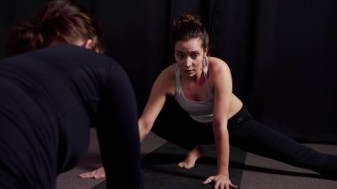 Antrenör, Asana için bacakların doğru konumunu gösterir.