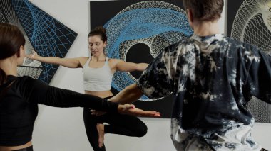 Denge eğitimi sırasında bir grup insan siyah ve mavi resimlerle odada.