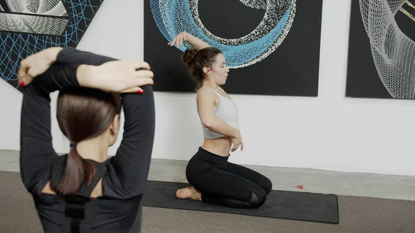 Donna sportiva che fa esercizio sul pavimento durante la lezione di yoga — Foto Stock
