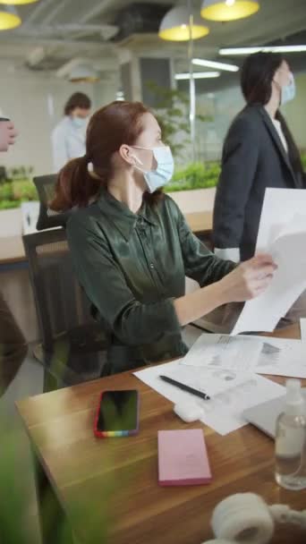 Μια νεαρή γυναίκα δίνει κάποια έγγραφα στο συνάδελφό της. — Αρχείο Βίντεο