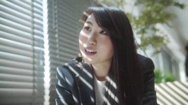 Güzel bir kadın meslektaşına bakıyor ve onunla konuşuyor.