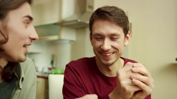 Zwei Freunde lachen und pressen Avocados in ihre Hände — Stockvideo