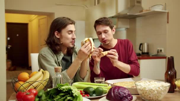 En av vännerna äter pizza och ger den till sin kompis. — Stockvideo