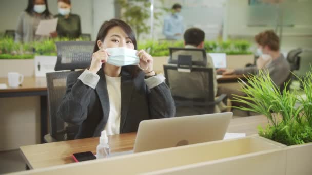 A beautiful lady is putting a protective mask on her face — Stock Video