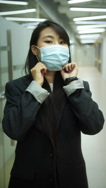 Een jonge vrouw zet een masker op haar gezicht. — Stockfoto