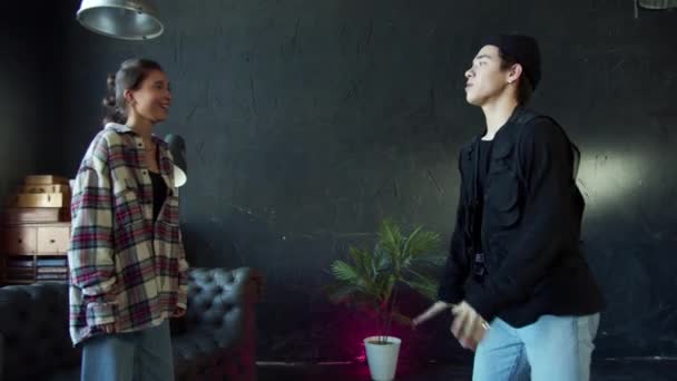 Stijlvolle jongen en meisje dansen hip-hop op zwarte achtergrond in de danszaal — Stockvideo