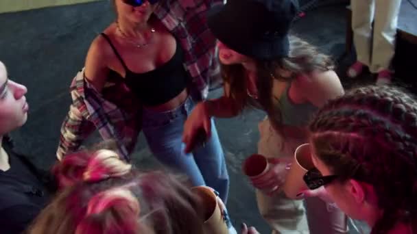 Sekelompok remaja menari di klub dengan minuman di cangkir — Stok Video