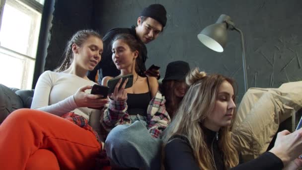 Los adolescentes comparten videos en una aplicación de redes sociales sentados en un sofá — Vídeo de stock