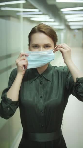 Eine junge Frau setzt sich eine Maske auf — Stockvideo