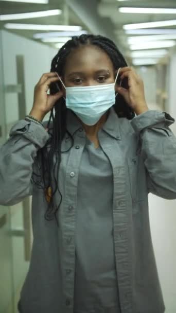 Uma jovem está colocando uma máscara em seu rosto — Vídeo de Stock