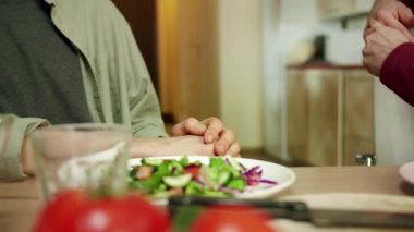 Arka planda iki adam yemekte konuşuyor.