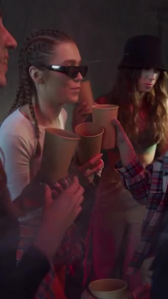 Teenager haben Spaß auf einer Party, tanzen in einer Rauchwolke in den Lichtstrahlen — Stockvideo