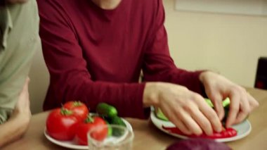 Genç bir adam arkadaşına iki olgun avokado gösteriyor. 
