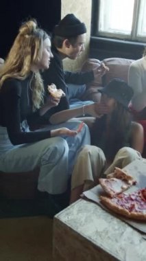 Bir grup genç uzun bir dans çalışmasından sonra pizza yiyor.