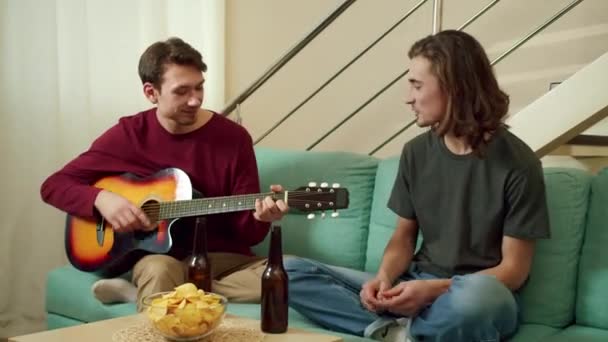Dos jóvenes tocan la guitarra y se divierten — Vídeos de Stock