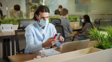 Yetişkin bir işadamı çalışırken telefonda biriyle konuşuyor.