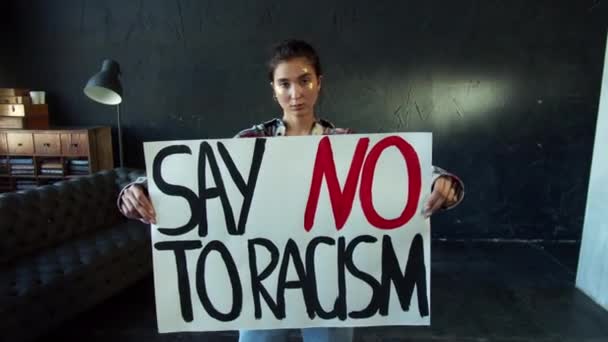 Fiatal lány, aki a faji megkülönböztetés elleni tiltakozás vagy figyelemfelkeltő kampány zászlajával rendelkezik — Stock videók