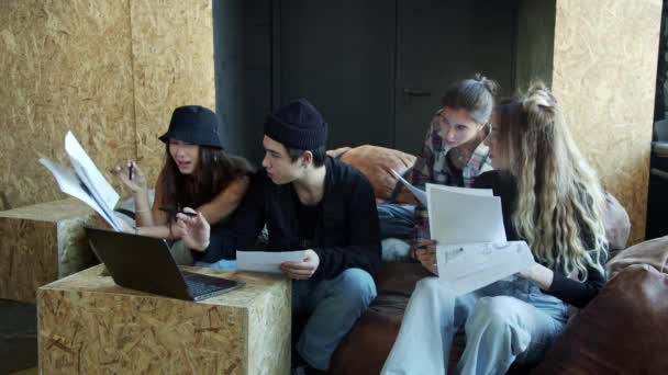 Trendy leerlingen doen het huiswerk samen met laptop thuis — Stockvideo