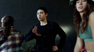 Çeşitli gençlerden oluşan bir grup modern bir dans yapıyor. 