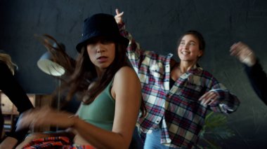 Siyah arka planda dans eden şık erkek ve kadın hip-hop yapıyor.