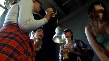 Küçük bir grup genç arka planda dans ediyor.