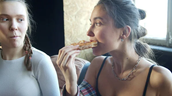 Nastolatki jedzą pyszną pizzę siedzącą blisko siebie. — Zdjęcie stockowe