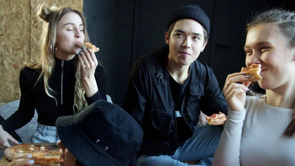 Jóvenes hipsters comiendo pizza en un estudio de baile — Foto de Stock