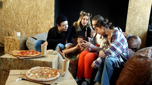 Οι έφηβοι κολλάνε στα τηλέφωνά τους αντί να τρώνε ζεστή πίτσα. — Φωτογραφία Αρχείου