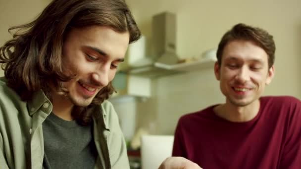 Zwei schöne Männer kochen zusammen und reden — Stockvideo