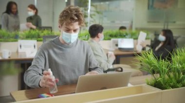 Genç bir işadamı ellerini dezenfekte ediyor.