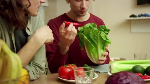 Deux charmants amis choisissent des feuilles de salade vertes — Video