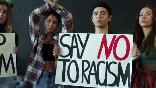 Chicas jóvenes y un tipo con pancartas de campaña de sensibilización contra la discriminación racial — Vídeos de Stock