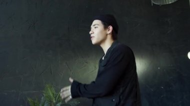 Siyah gömlekli adam bir kızı dans savaşına çağırıyor.