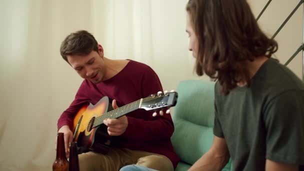 Dos amigos están tocando la guitarra y cantando canciones — Vídeos de Stock